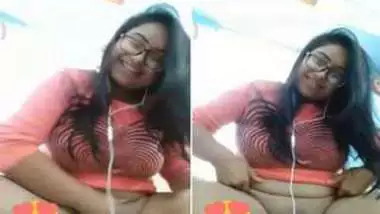 Smiling Indian with glasses listens to music and undresses at once